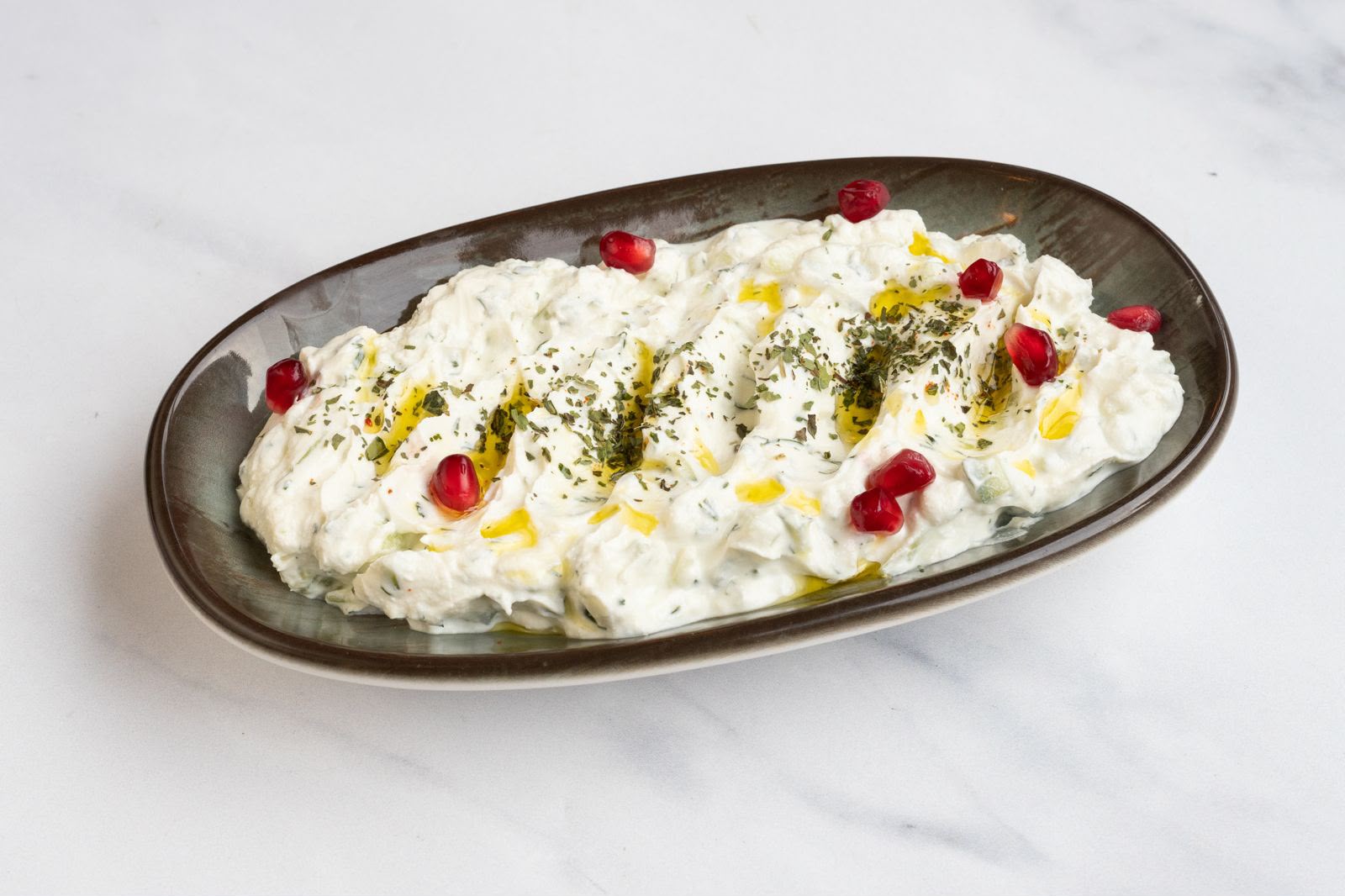 Cacik, a cool Turkish yogurt and cucumber dip drizzled with olive oil and dried mint.