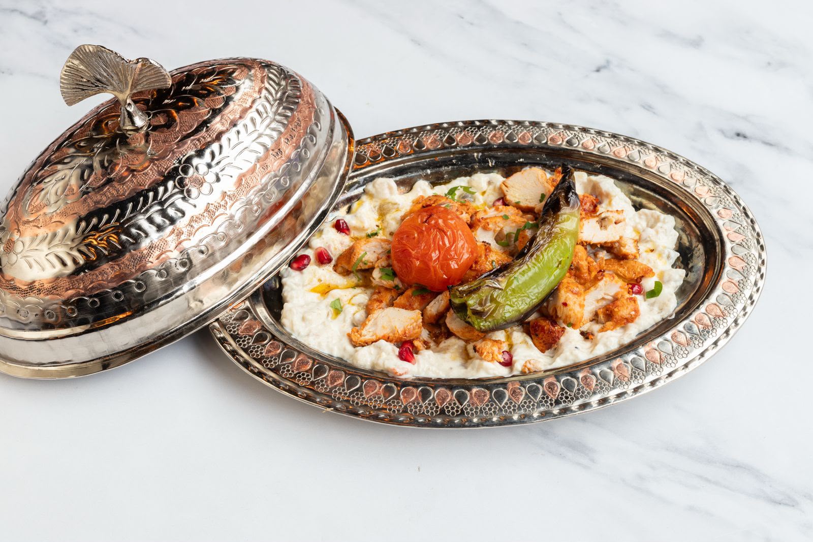 Chicken ali nazik on smoked aubergine yogurt, served in a traditional copper dish at The Kervan.