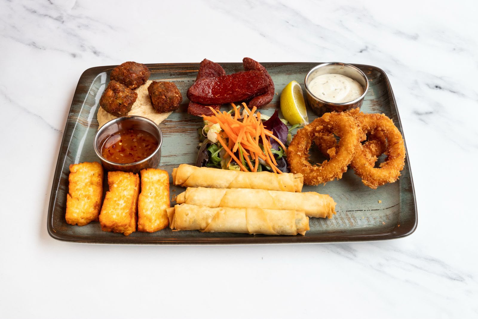 Hot meze sharing platter with falafel, sucuk, grilled halloumi, borek rolls and crispy calamari.